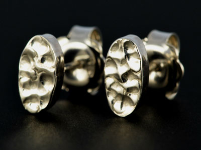 Handmade, chunky oval studs in sterling silver with a punched effect finish